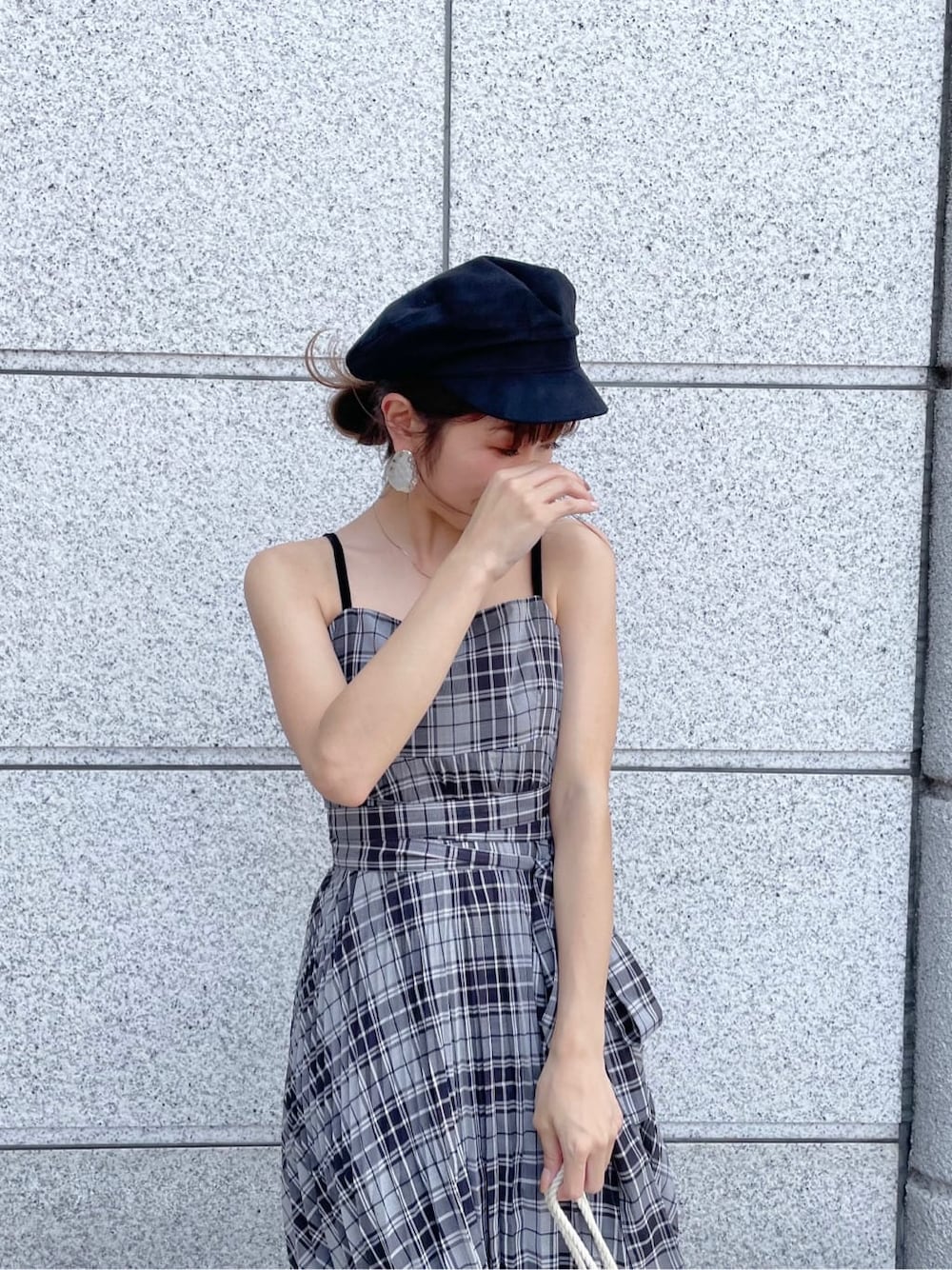 ブラック系のワンピース、ホワイト系のスニーカー、ブラック系のキャスケットを着用したレディースの夏コーディネートの2枚目の写真