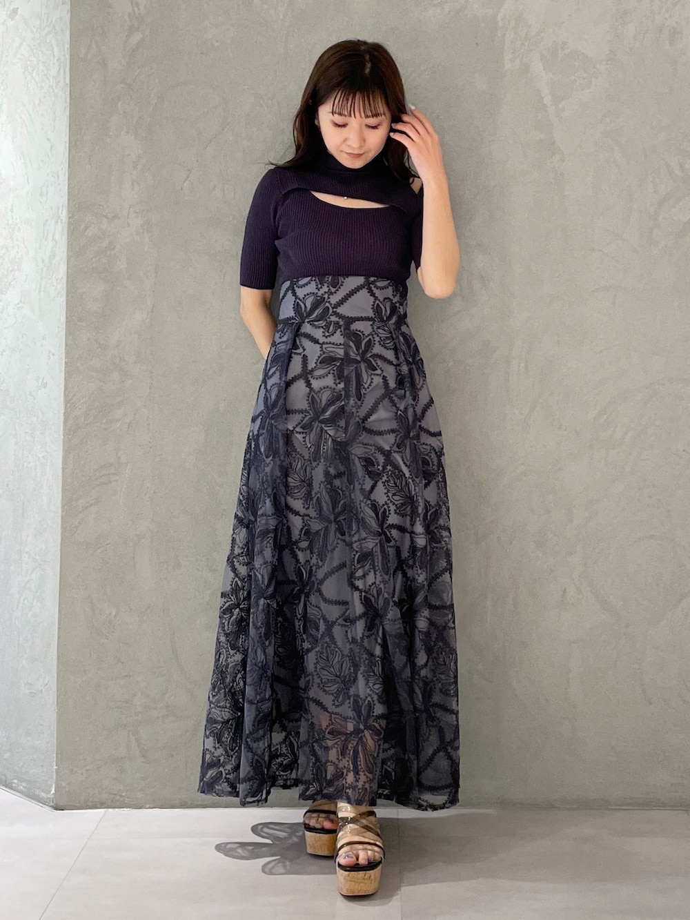 グレー系のスカート、ブラック系のサンダル、グレー系のニット/セーターを着用したレディースの春コーディネートの6枚目の写真