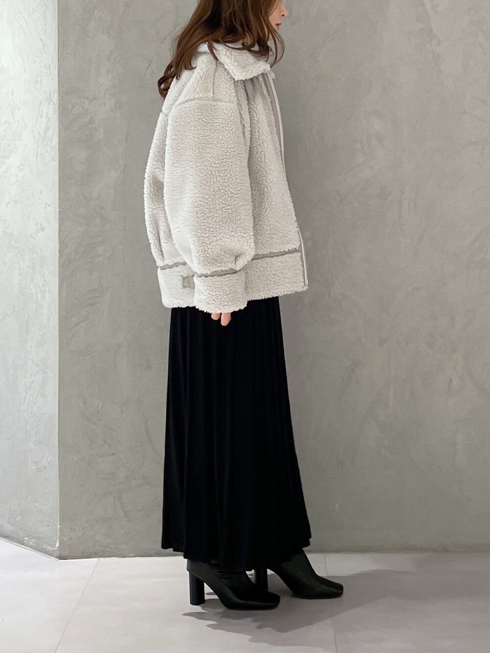 ブラック系のワンピース、ブラック系のブーツ、グレー系のその他アウターを着用したレディースの冬コーディネートの4枚目の写真