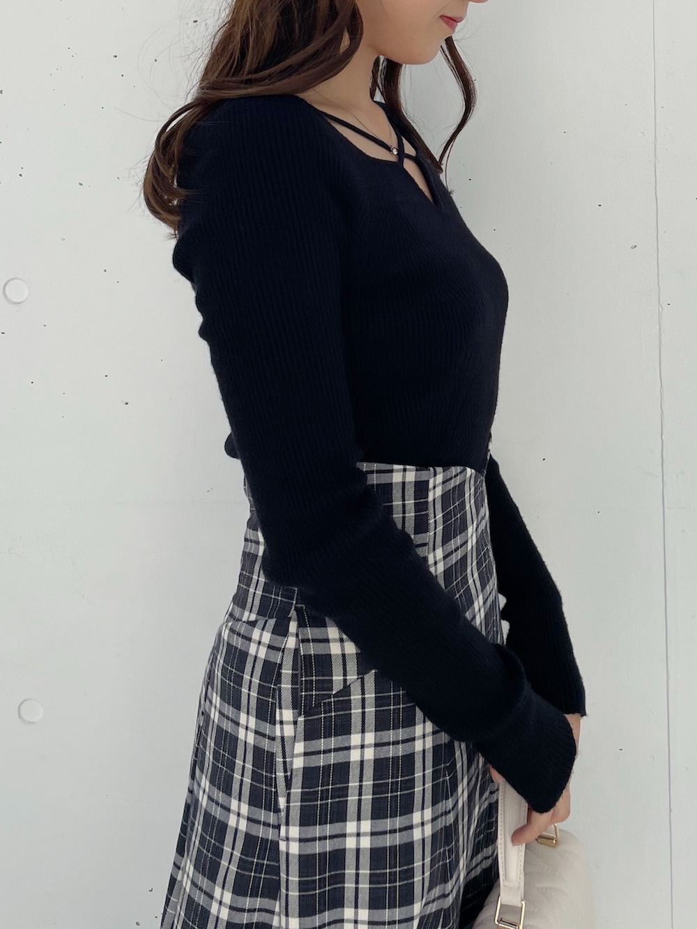 ブラック系のスカート、ブラック系のブーツ、ブラック系のニット/セーターを着用したレディースの秋コーディネートの5枚目の写真