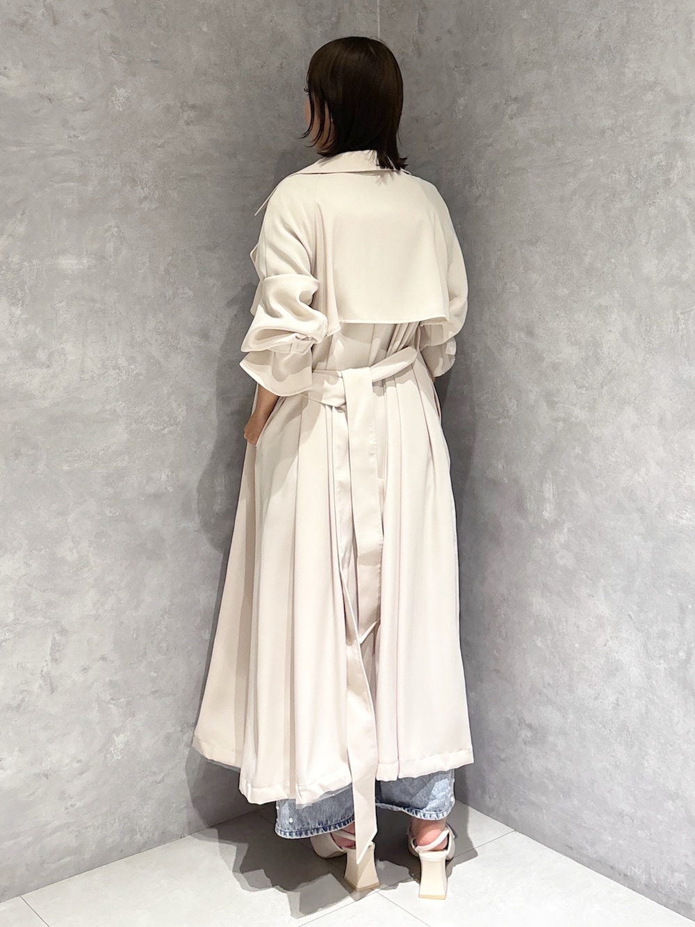 ブルー系のデニムパンツ、その他のニット/セーター、ホワイト系のトレンチコートを着用したレディースの春コーディネートの3枚目の写真