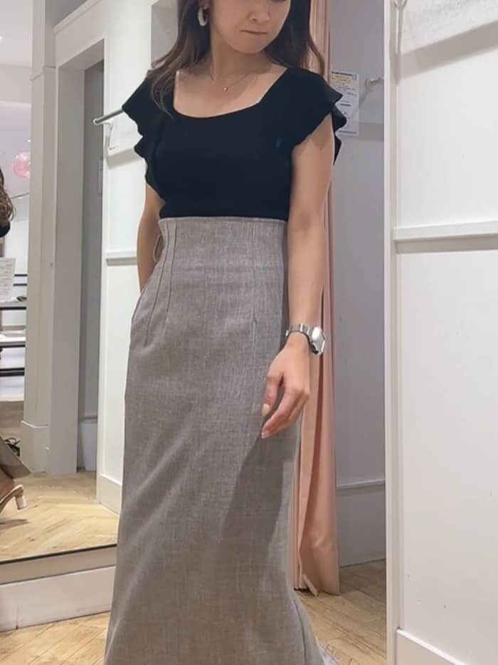 ブラウン系のスカート、ブラック系のニット/セーター、ベージュ系のサンダルを着用したレディースの夏コーディネートの2枚目の写真