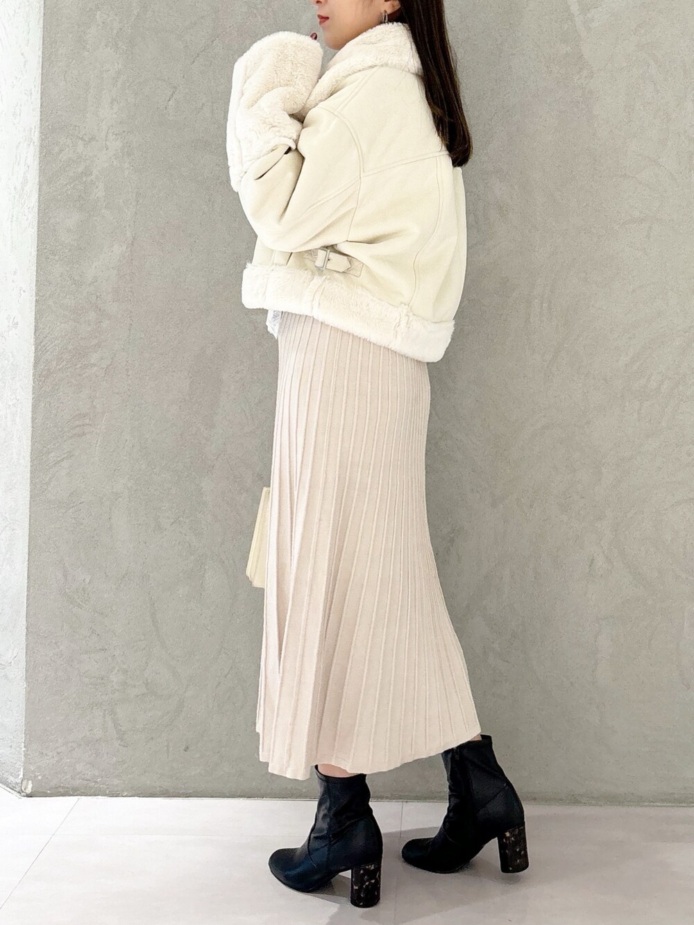 ホワイト系のワンピース、ブラック系のブーツ、ホワイト系のハンドバッグを着用したレディースの秋コーディネートの3枚目の写真