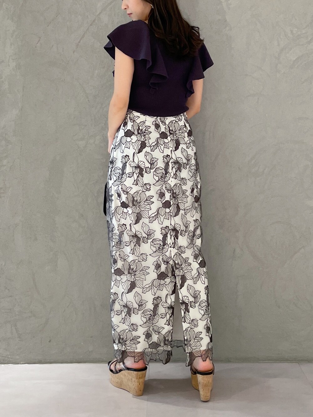 ブラック系のハンドバッグ、ブラック系のサンダル、グレー系のニット/セーターを着用したレディースの春コーディネートの5枚目の写真