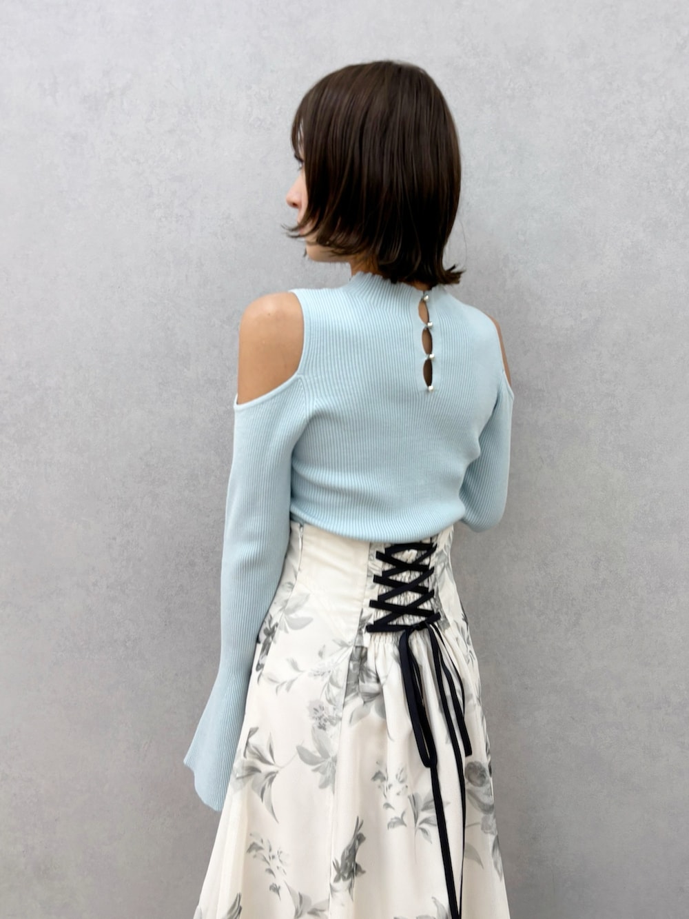 ホワイト系のスカート、グリーン系のニット/セーター、ホワイト系のパンプスを着用したレディースの春コーディネートの9枚目の写真