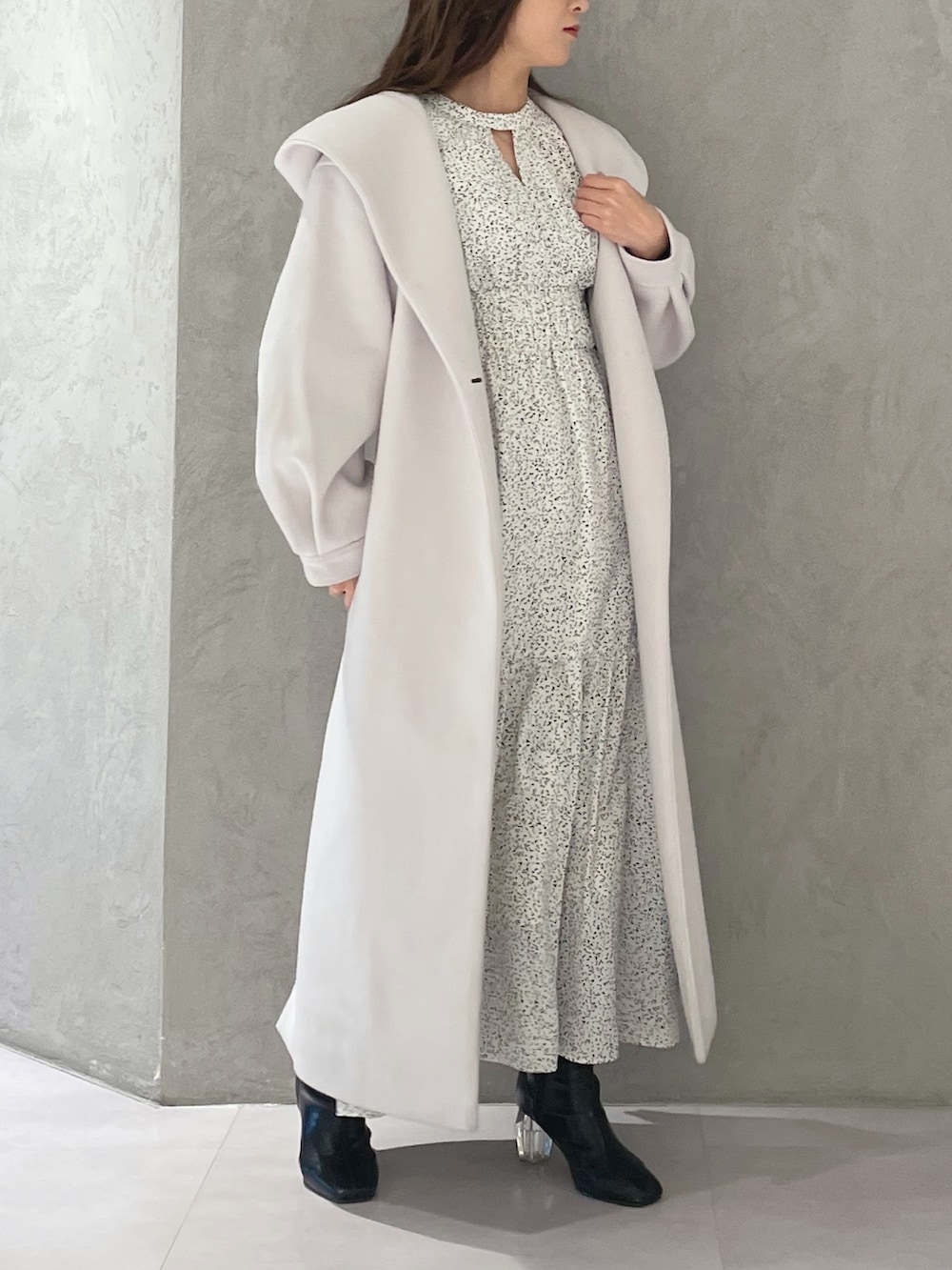 ホワイト系のワンピース、ホワイト系のチェスターコート、ブラック系のブーツを着用したレディースの冬コーディネートの2枚目の写真