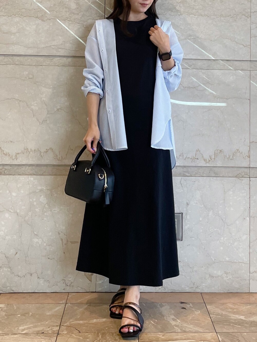 ホワイト系のボストンバッグ、ブラック系のサンダル、ブルー系のシャツ/ブラウスを着用したレディースの春コーディネートの4枚目の写真