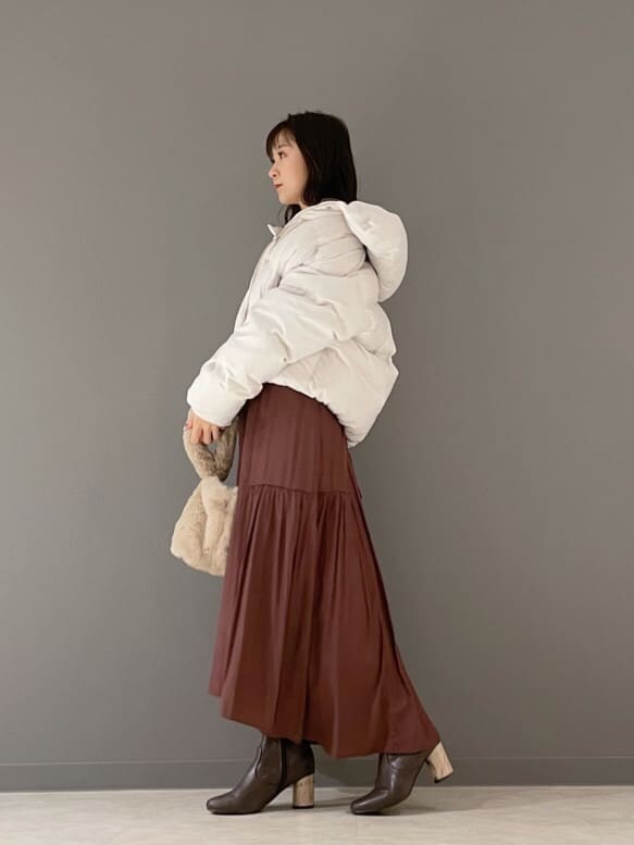 ホワイト系のその他アウター、ブラウン系のワンピース、ベージュ系のハンドバッグを着用したレディースの冬コーディネートの7枚目の写真