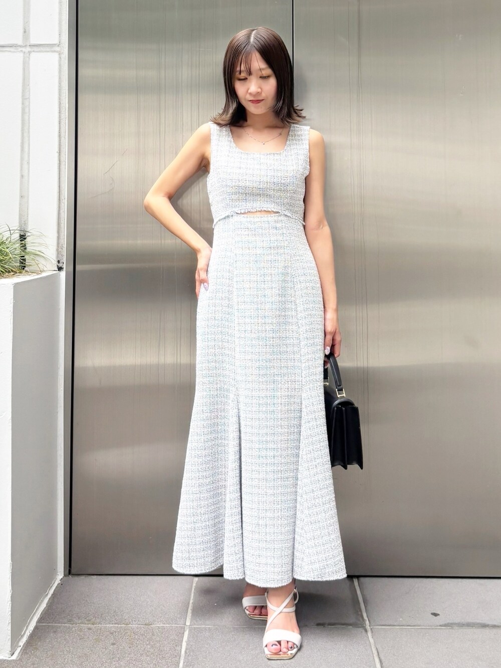 グレー系のワンピース、ホワイト系のサンダル、ブラック系のハンドバッグを着用したレディースの夏コーディネートの8枚目の写真