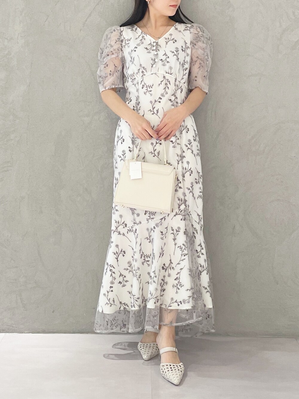 ホワイト系のショルダーバッグ、ホワイト系のパンプス、グレー系のワンピースを着用したレディースの春コーディネートの6枚目の写真