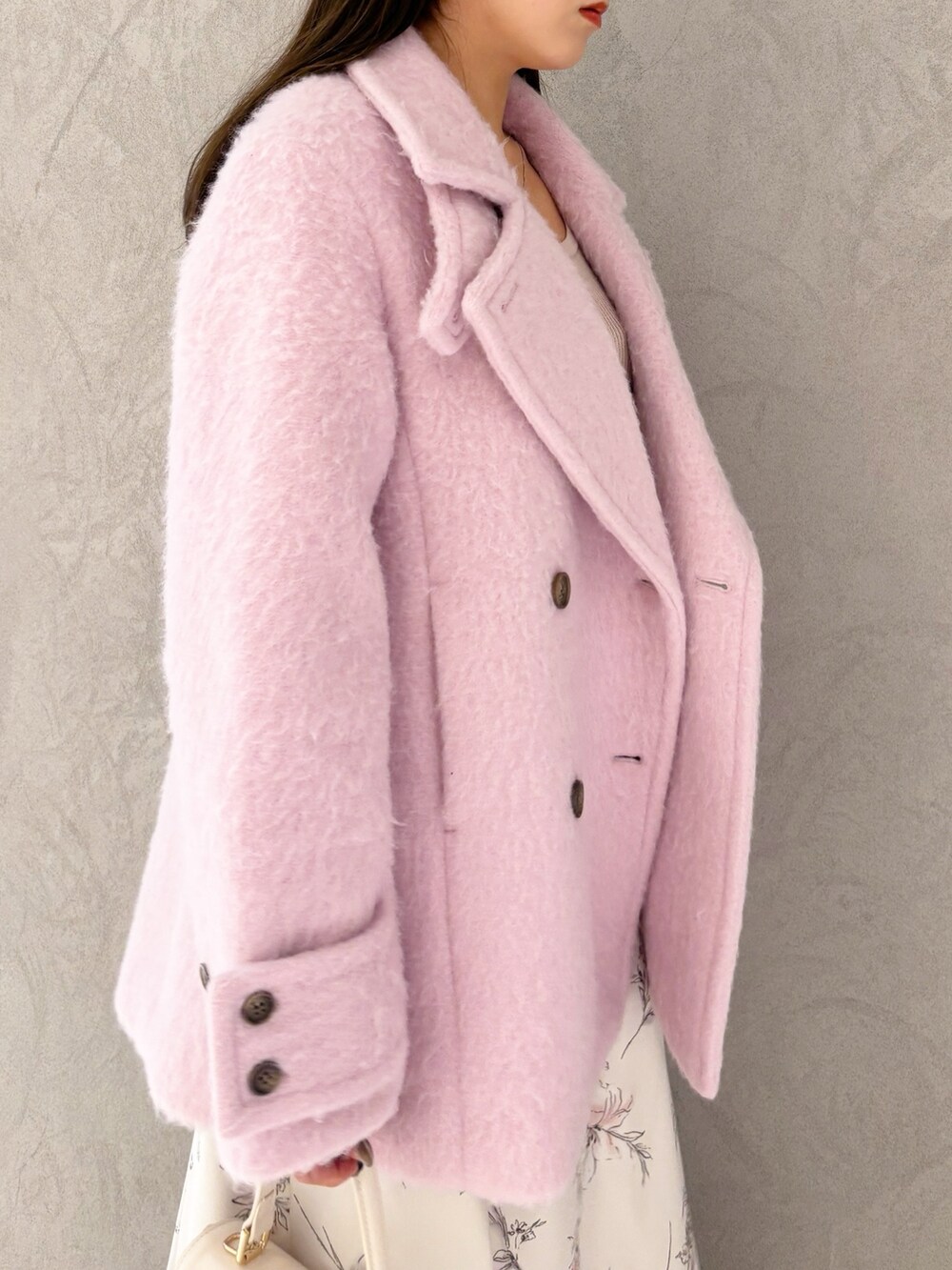 ベージュ系のワンピース、ブラック系のブーツ、ホワイト系のハンドバッグを着用したレディースの冬コーディネートの4枚目の写真