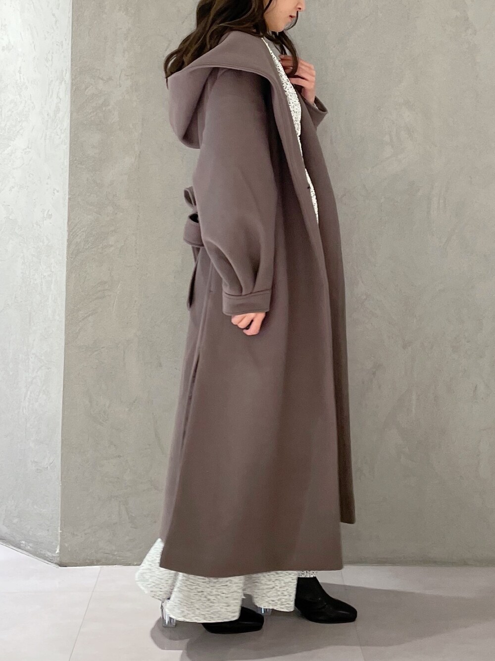 ホワイト系のワンピース、ブラウン系のチェスターコート、ブラック系のブーツを着用したレディースの秋コーディネートの5枚目の写真