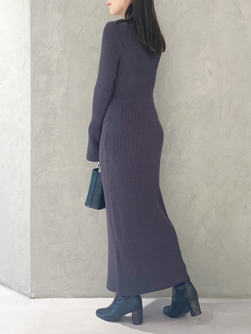 ブラック系のハンドバッグ、ブラック系のブーツ、グレー系のワンピースを着用したレディースの冬コーディネートの4枚目の写真