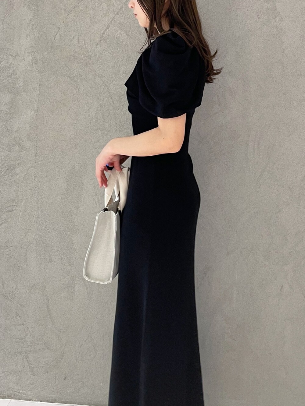 グレー系のワンピース、シルバー系のサンダル、グレー系のハンドバッグを着用したレディースの春コーディネートの2枚目の写真