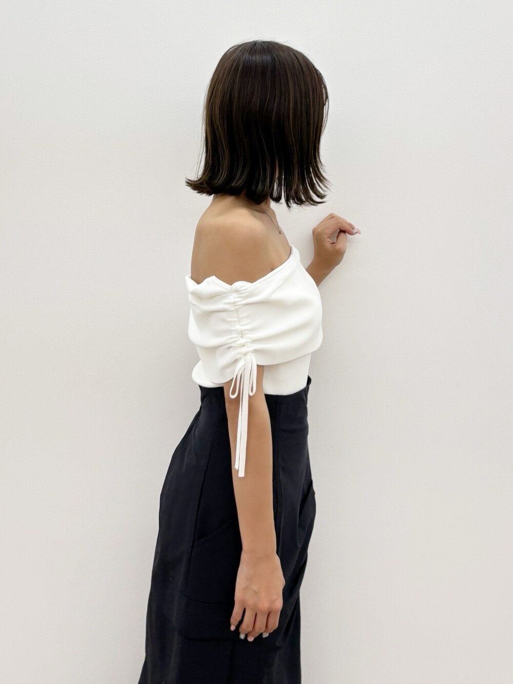 ブラック系のスカート、ホワイト系のニット/セーターを着用したレディースの夏コーディネートの8枚目の写真