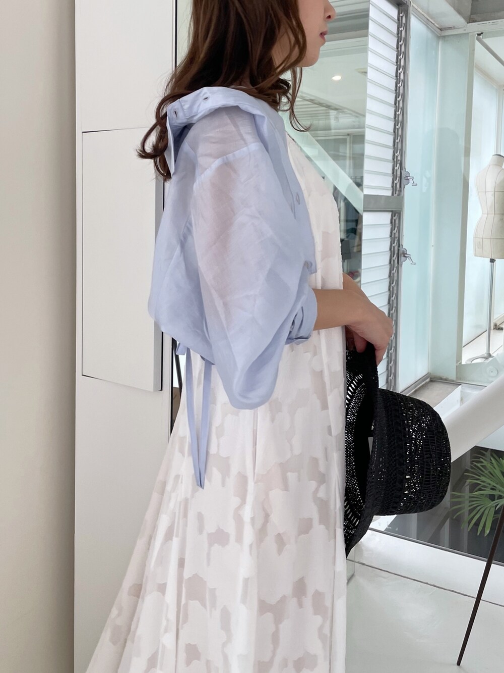 ホワイト系のワンピース、ブルー系のシャツ/ブラウス、ブラック系のサンダルを着用したレディースの春コーディネートの2枚目の写真