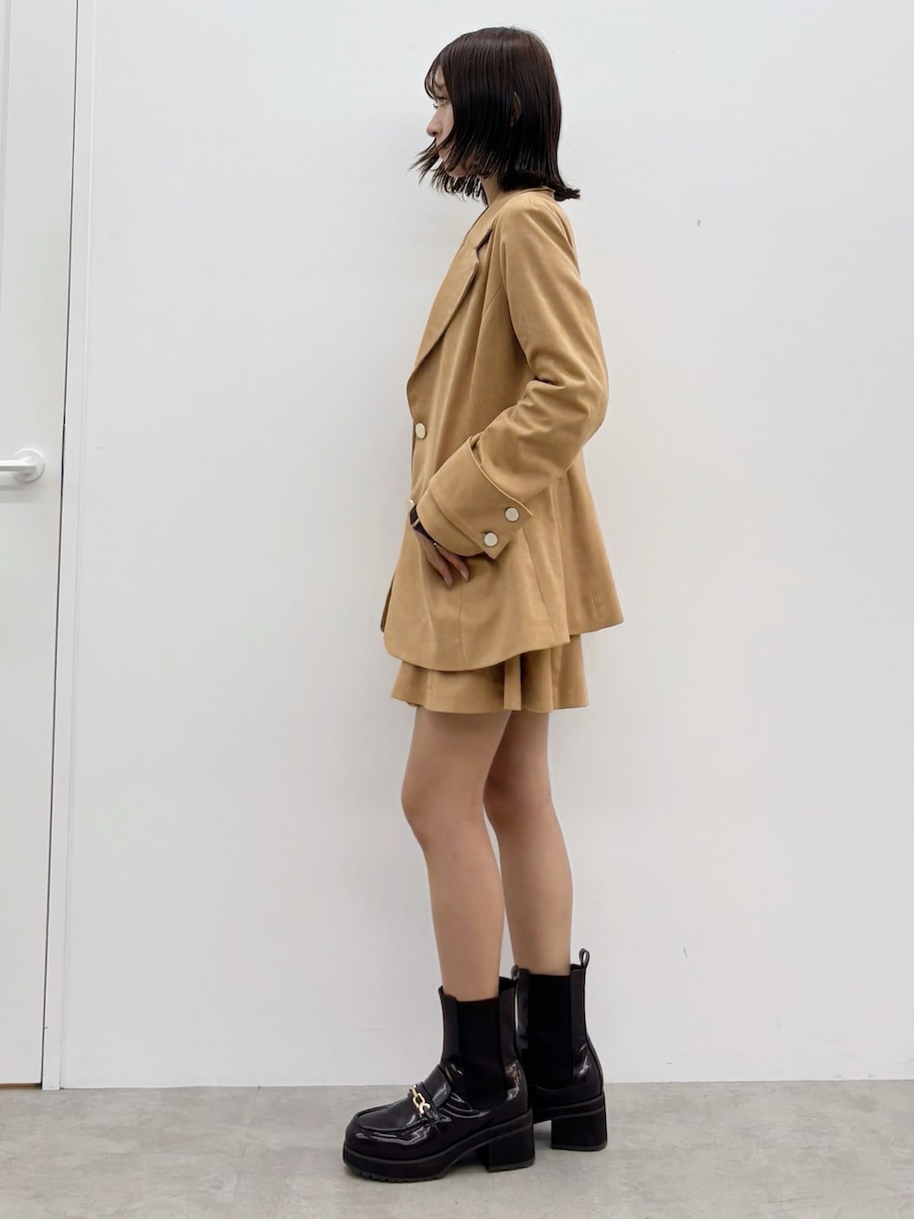 ブラウン系のニット/セーター、ブラウン系のスカート、ブラウン系のテーラードジャケットを着用したレディースの秋コーディネートの5枚目の写真