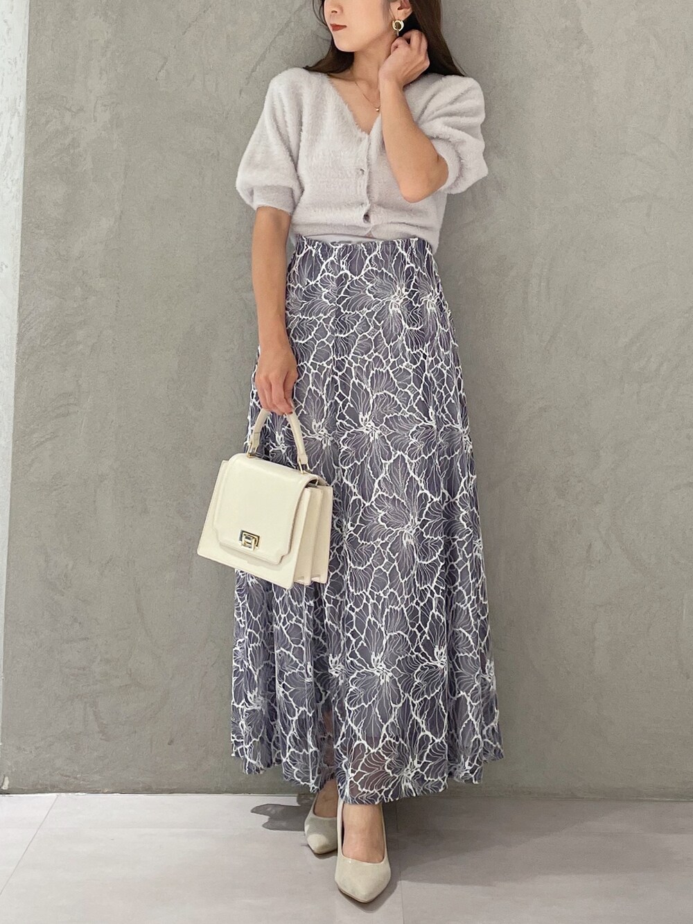 グレー系のカーディガン/ボレロ、ホワイト系のハンドバッグ、ホワイト系のパンプスを着用したレディースの夏コーディネートの3枚目の写真