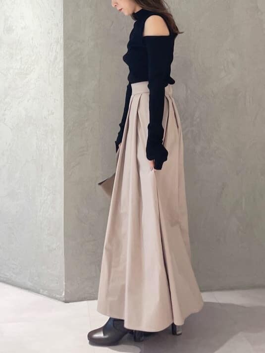 ブラウン系のブーツ、ブラック系のニット/セーター、ピンク系のスカートを着用したレディースの夏コーディネートの2枚目の写真