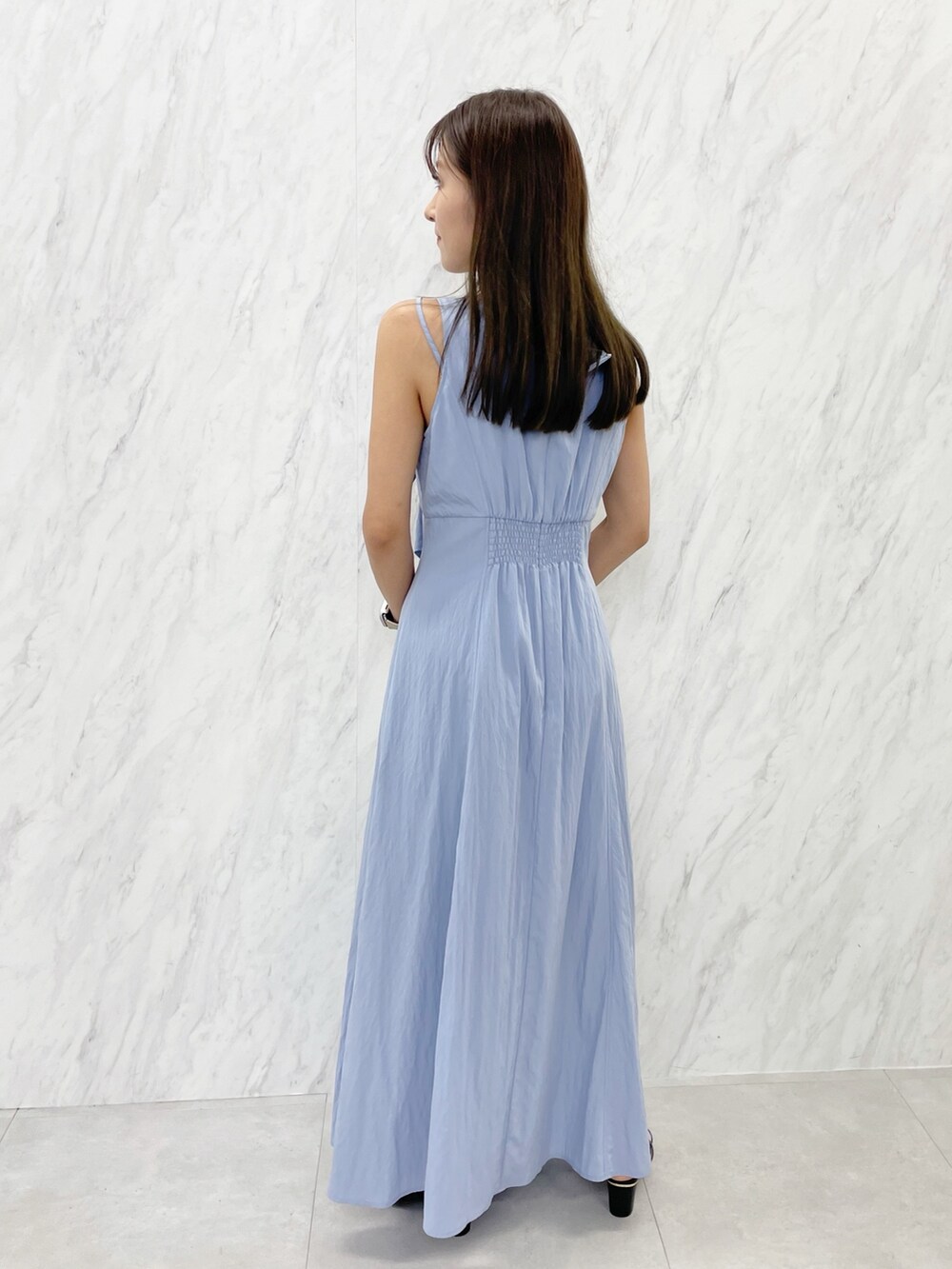 ブルー系のワンピース、ブラック系のサンダル、ホワイト系のハンドバッグを着用したレディースの夏コーディネートの5枚目の写真