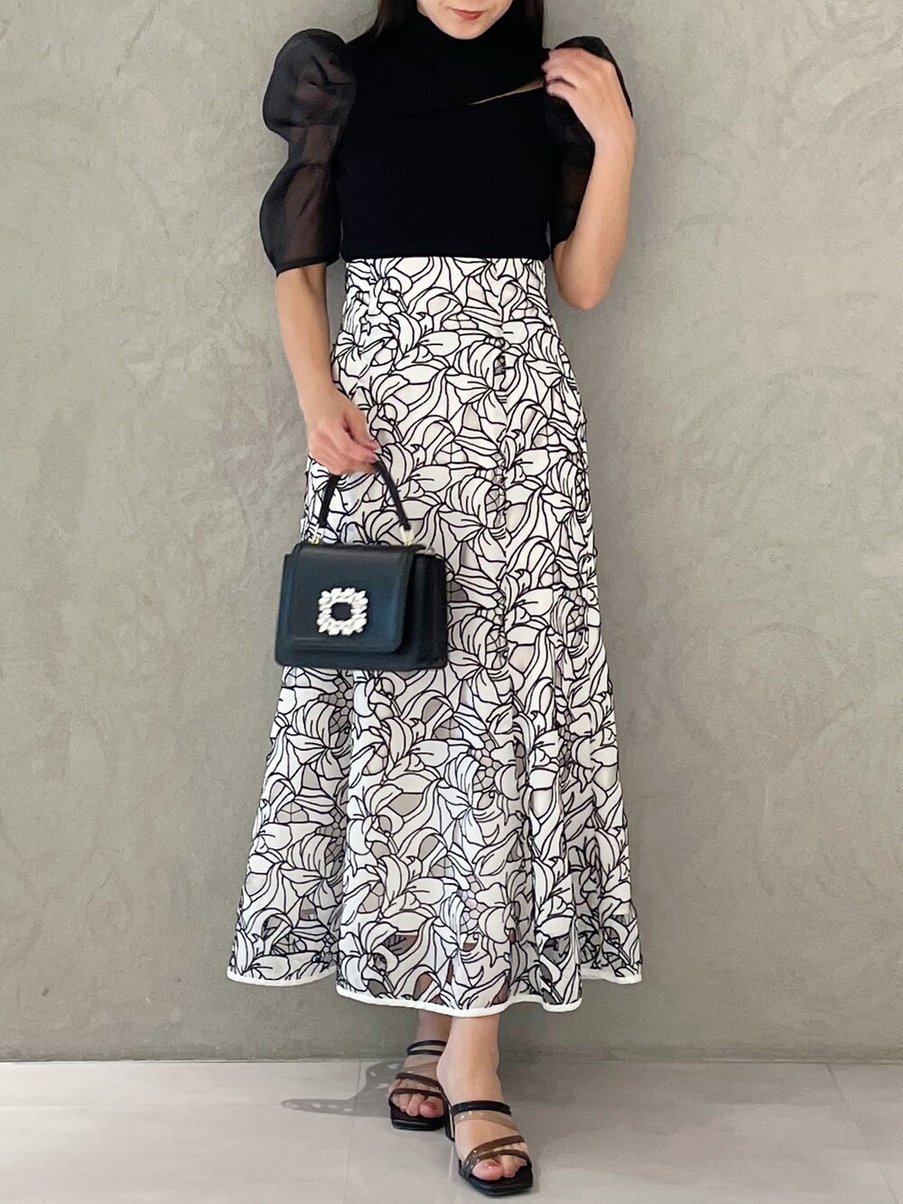 ホワイト系のスカート、ブラック系のサンダル、ブラック系のショルダーバッグを着用したレディースの夏コーディネートの5枚目の写真