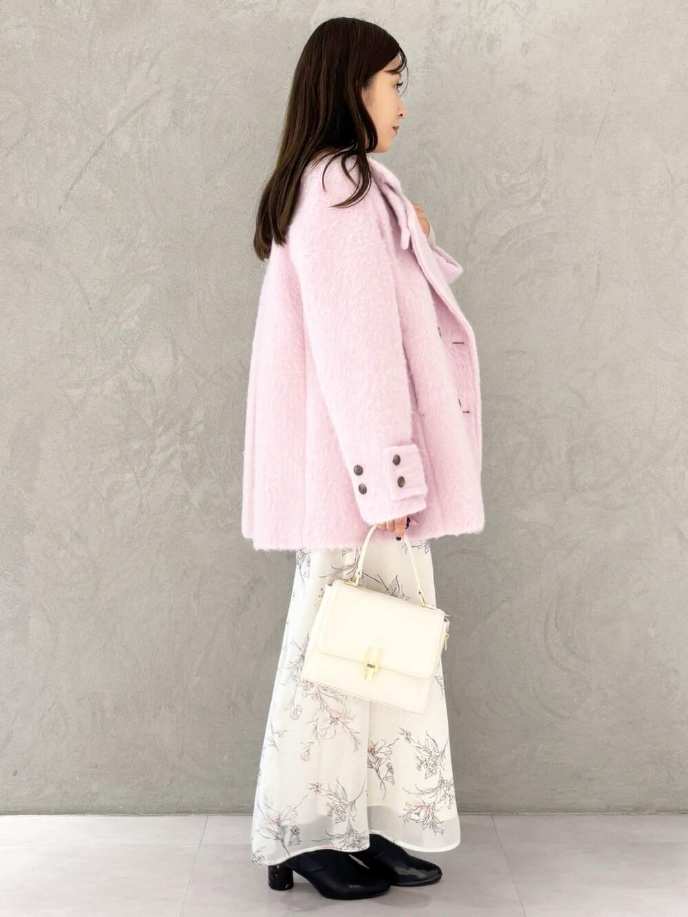 ベージュ系のワンピース、ブラック系のブーツ、ホワイト系のハンドバッグを着用したレディースの冬コーディネートの7枚目の写真