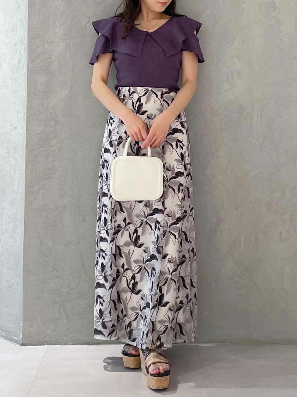 ホワイト系のハンドバッグ、ブラック系のサンダル、パープル系のニット/セーターを着用したレディースの春コーディネートの9枚目の写真