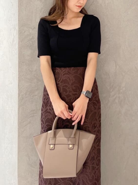 ブラウン系のハンドバッグ、ブラック系のニット/セーター、ブラック系のブーツを着用したレディースの夏コーディネートの2枚目の写真