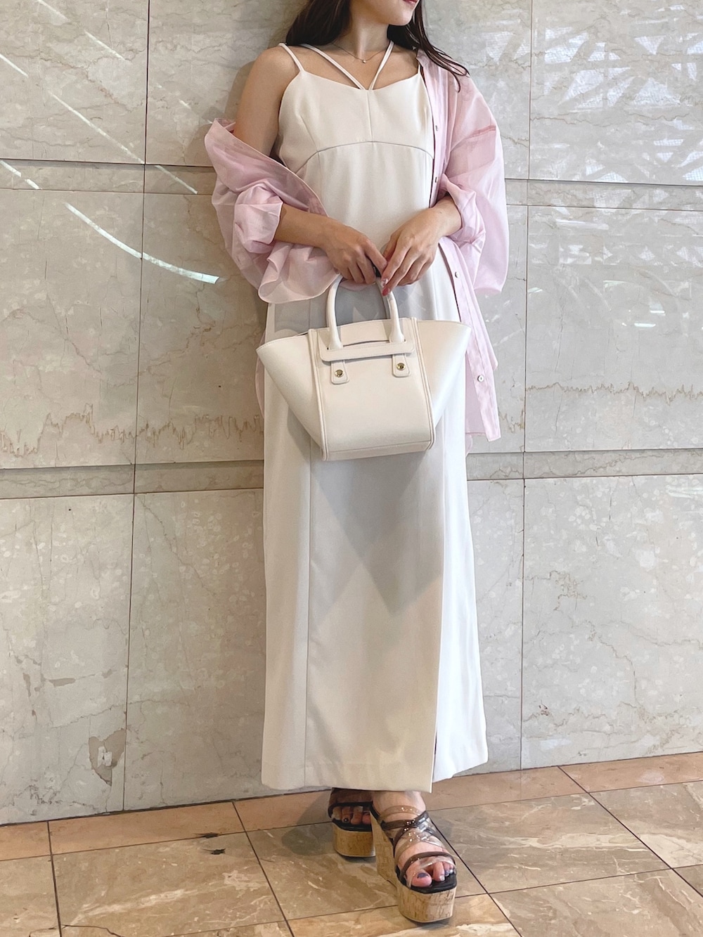 ホワイト系のトートバッグ、ブラック系のサンダル、ベージュ系のワンピースを着用したレディースの夏コーディネートの6枚目の写真