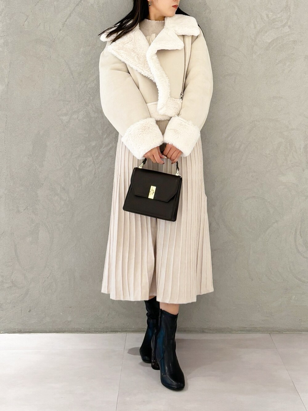 ホワイト系のワンピース、ブラック系のブーツ、ホワイト系のムートンコートを着用したレディースの秋コーディネートの7枚目の写真