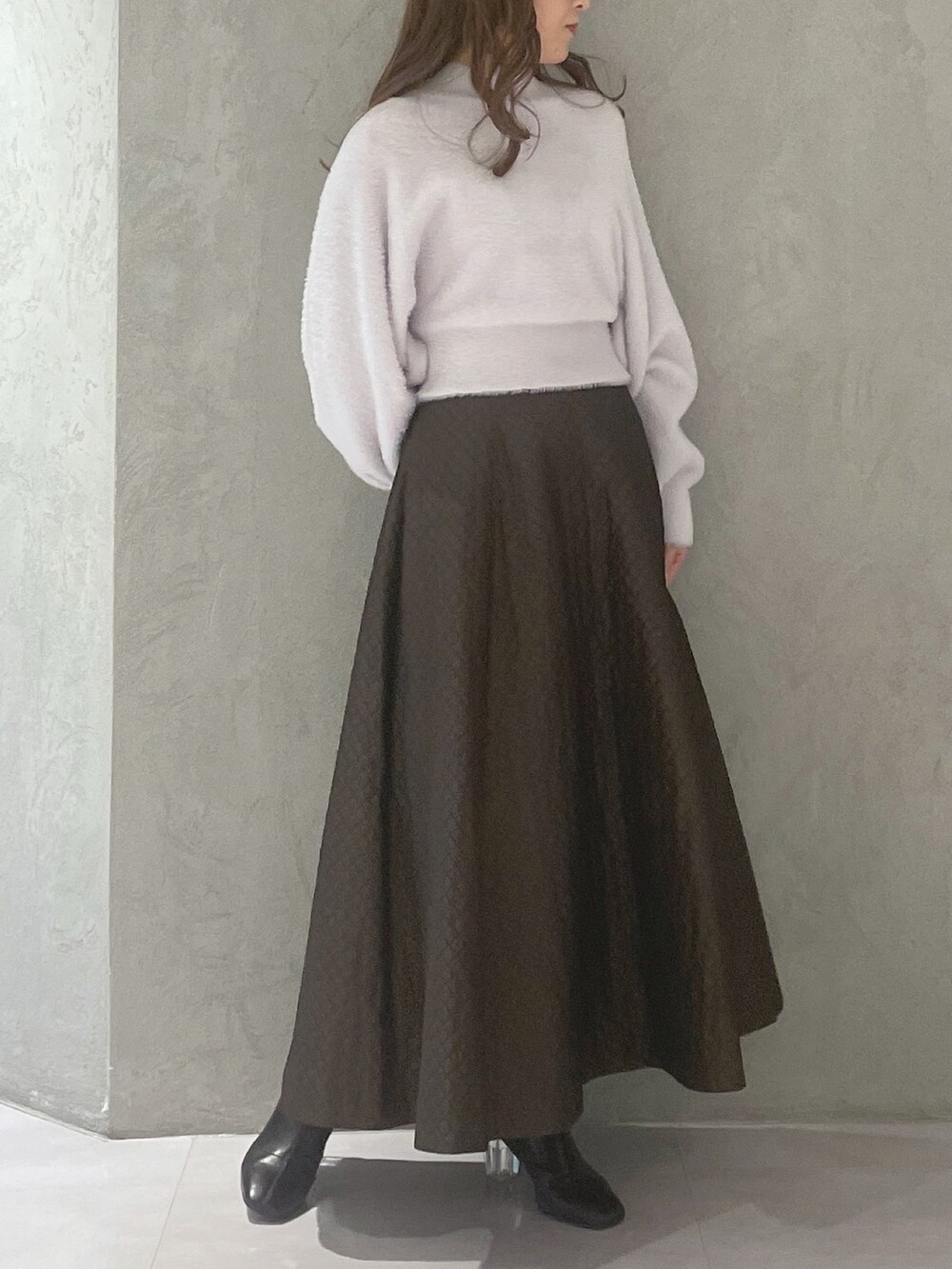 ブラウン系のスカート、パープル系のニット/セーターを着用したレディースの冬コーディネートの5枚目の写真