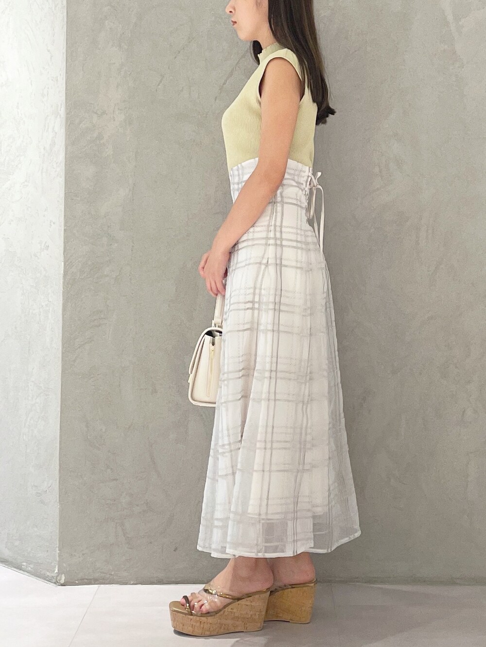 グリーン系のワンピース、ブラウン系のサンダル、ホワイト系のショルダーバッグを着用したレディースの夏コーディネートの3枚目の写真