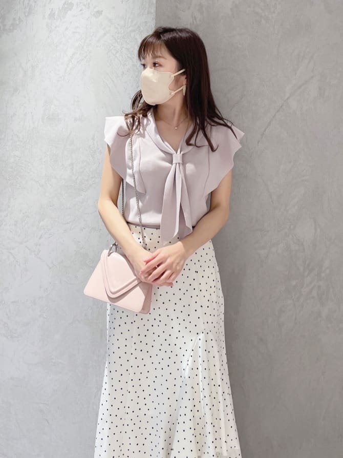 ピンク系のショルダーバッグ、グリーン系のサンダル、ピンク系のニット/セーターを着用したレディースの春コーディネートの2枚目の写真