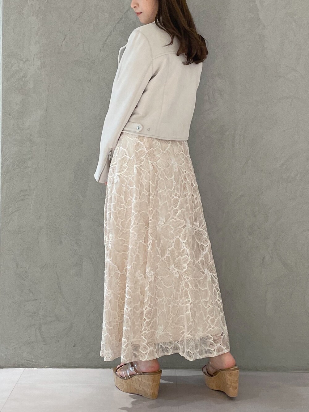 ブラウン系のサンダル、ホワイト系のニット/セーター、ホワイト系のライダースジャケットを着用したレディースの春コーディネートの5枚目の写真