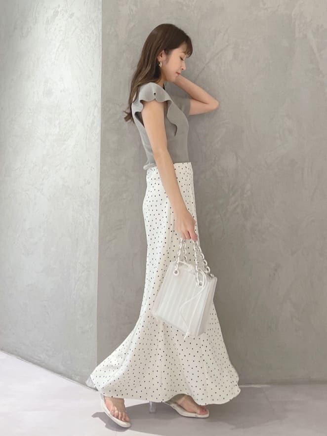 ホワイト系のハンドバッグ、グリーン系のサンダル、ホワイト系のスカートを着用したレディースの春コーディネートの3枚目の写真