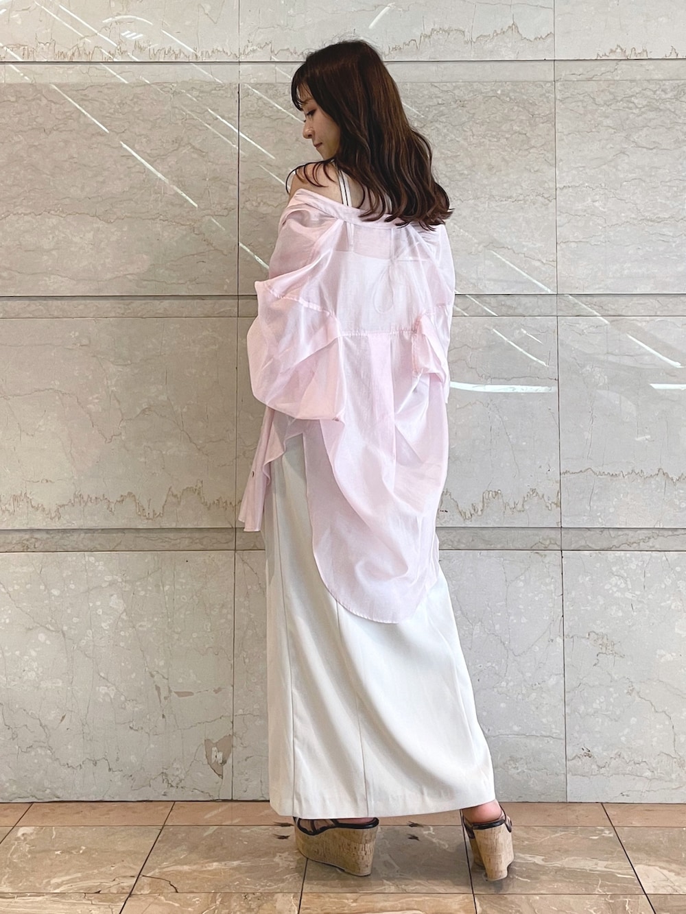 ホワイト系のトートバッグ、ブラック系のサンダル、ベージュ系のワンピースを着用したレディースの夏コーディネートの3枚目の写真