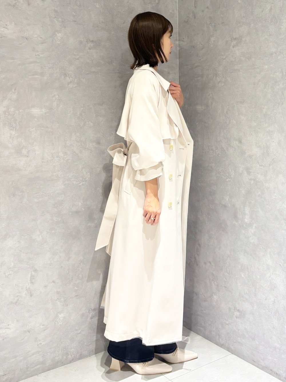 ブルー系のデニムパンツ、ホワイト系のパンプス、イエロー系のニット/セーターを着用したレディースの冬コーディネートの6枚目の写真