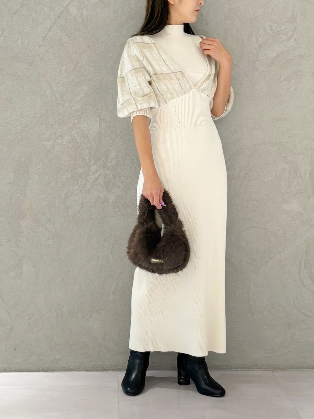 ホワイト系のワンピース、ブラック系のブーツ、ブラウン系のハンドバッグを着用したレディースの秋コーディネートの2枚目の写真