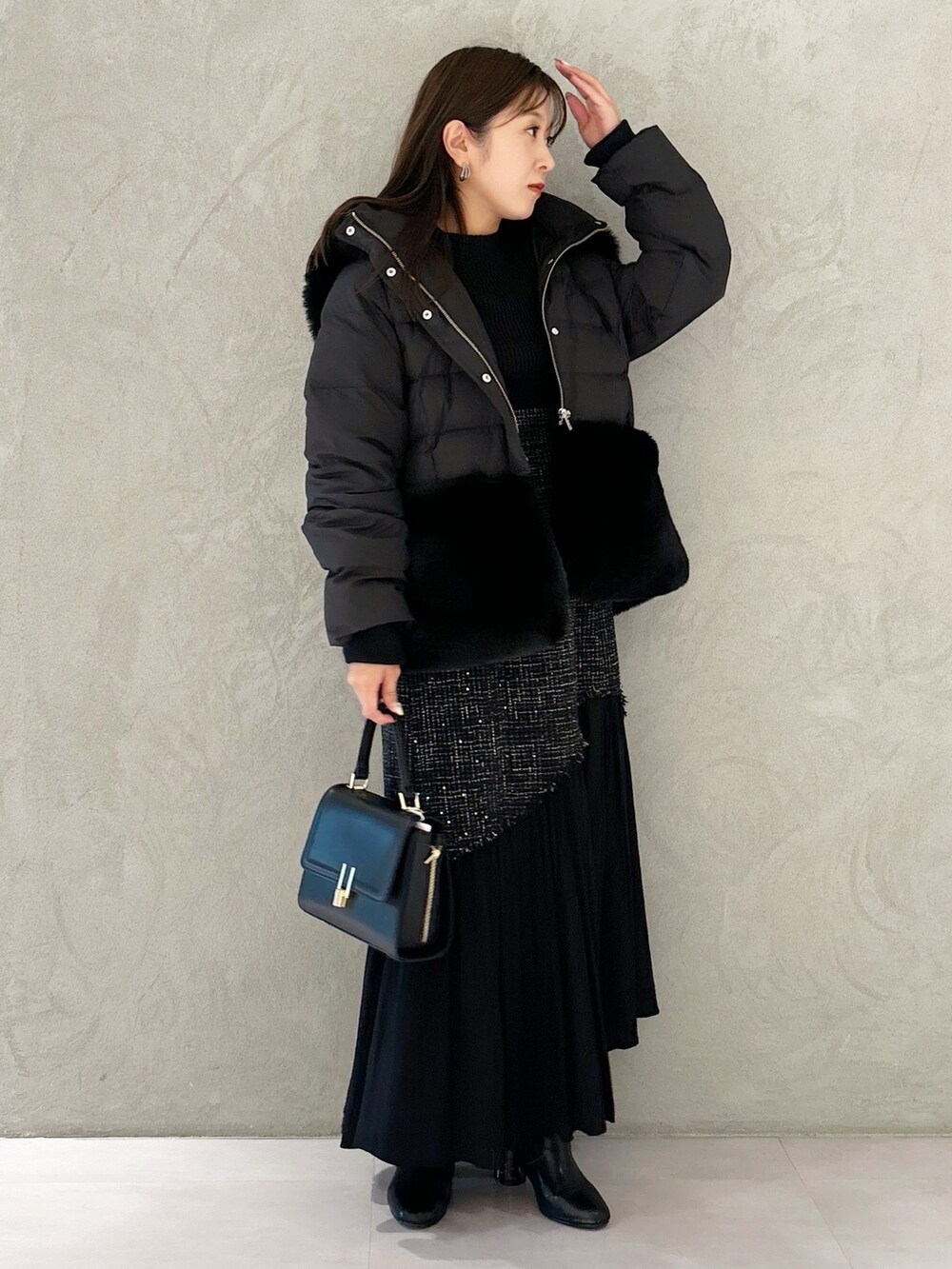 ブラック系のスカート、ブラック系のブーツ、ブラック系のショルダーバッグを着用したレディースの秋コーディネートの2枚目の写真