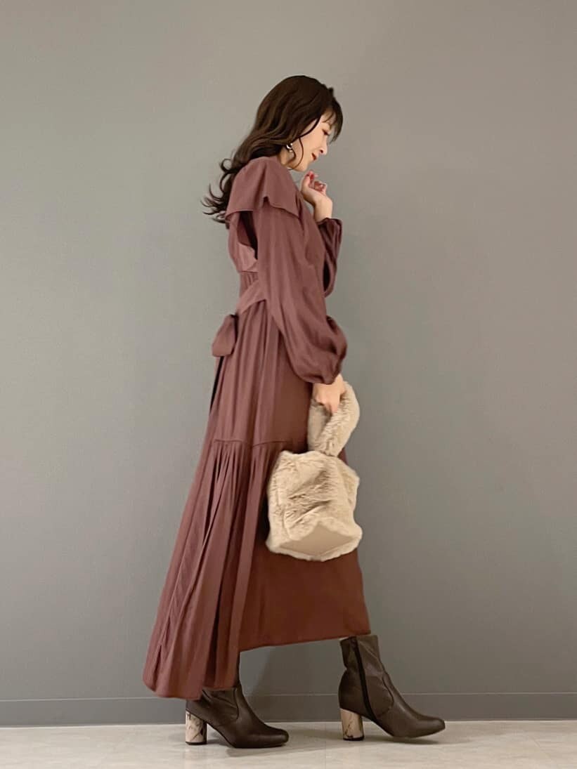 ホワイト系のその他アウター、ブラウン系のワンピース、ベージュ系のハンドバッグを着用したレディースの冬コーディネートの2枚目の写真