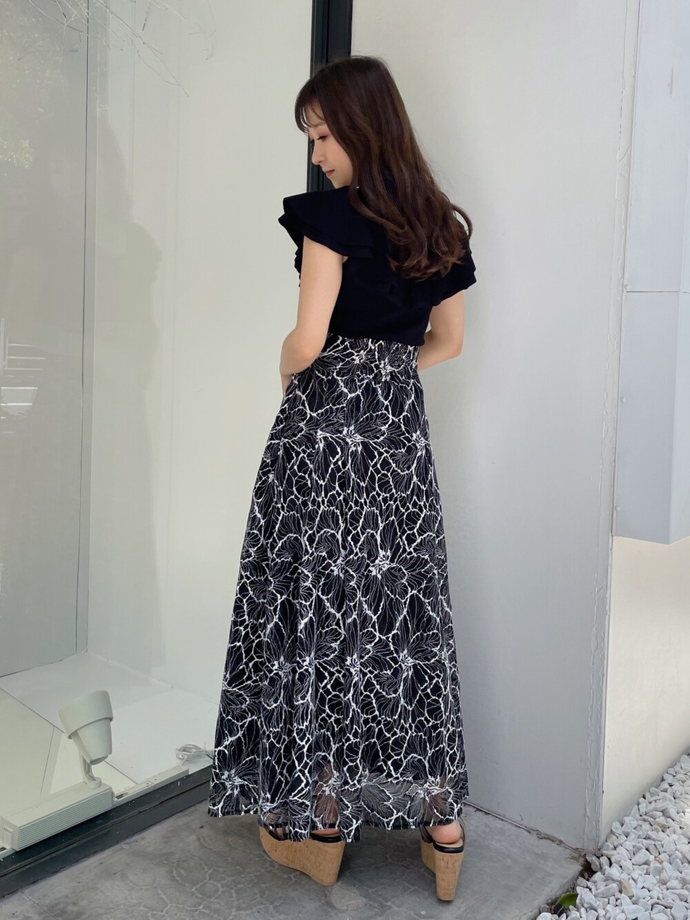 ブラック系のスカート、ブラック系のサンダル、ブラック系のニット/セーターを着用したレディースの夏コーディネートの3枚目の写真