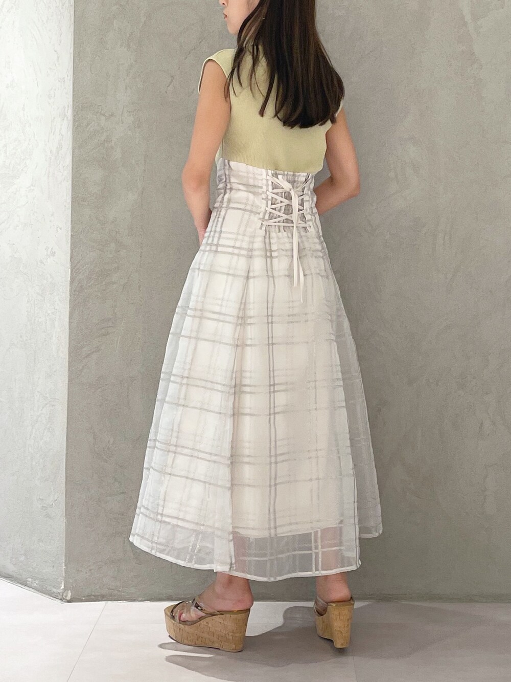 グリーン系のワンピース、ブラウン系のサンダル、ホワイト系のショルダーバッグを着用したレディースの夏コーディネートの4枚目の写真