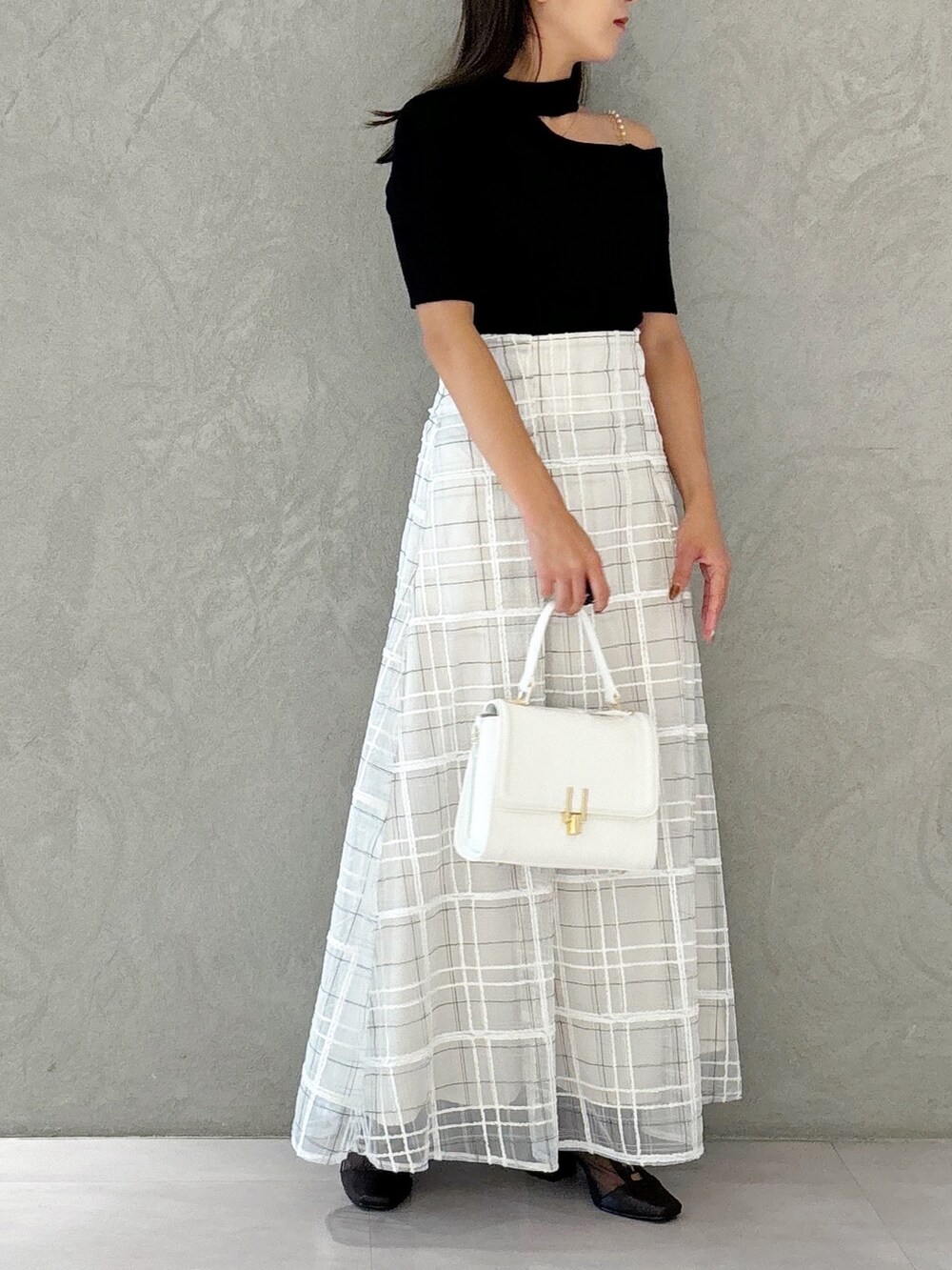 ホワイト系のスカート、ブラウン系のブーツ、ホワイト系のショルダーバッグを着用したレディースの秋コーディネートの5枚目の写真