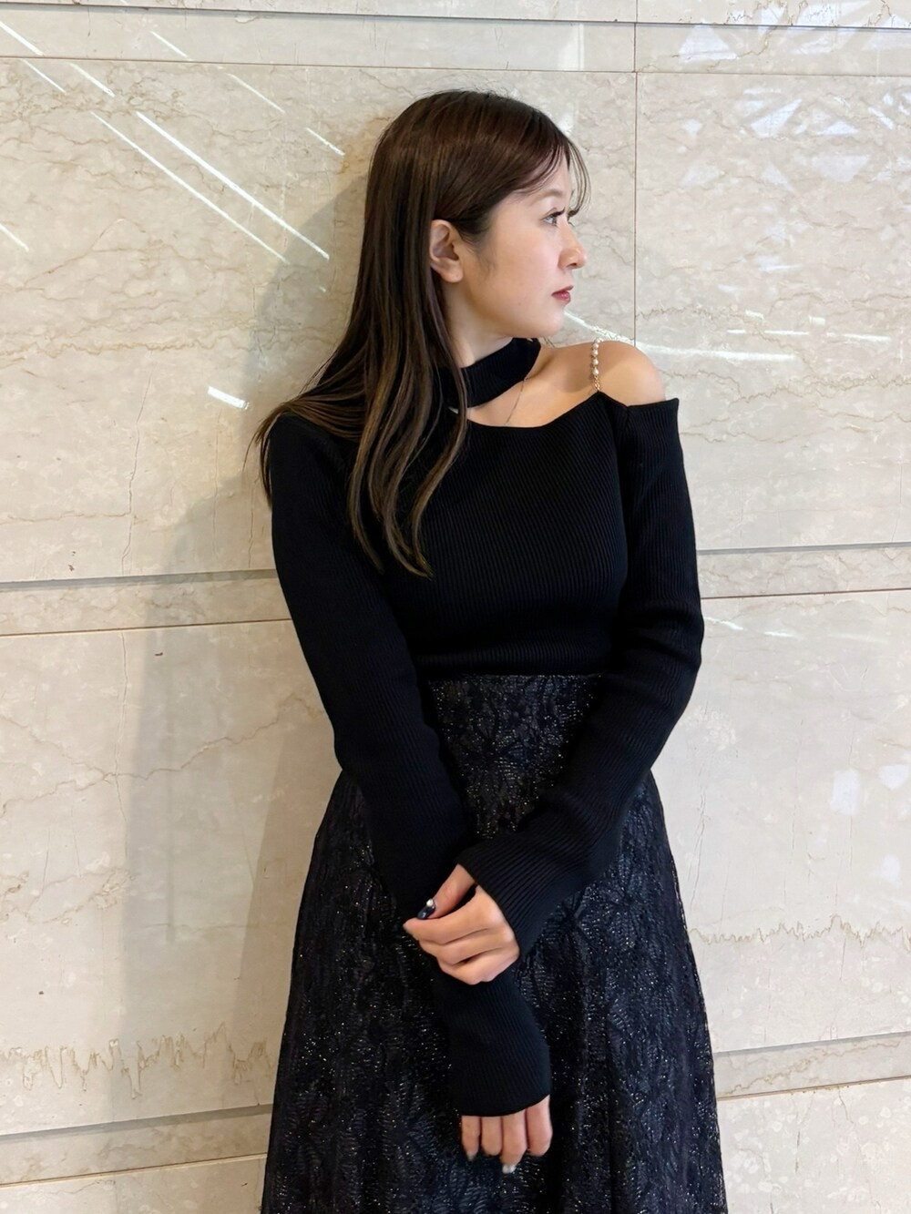 ブラック系のスカート、ブラック系のニット/セーター、ブラック系のブーツを着用したレディースの冬コーディネートの3枚目の写真