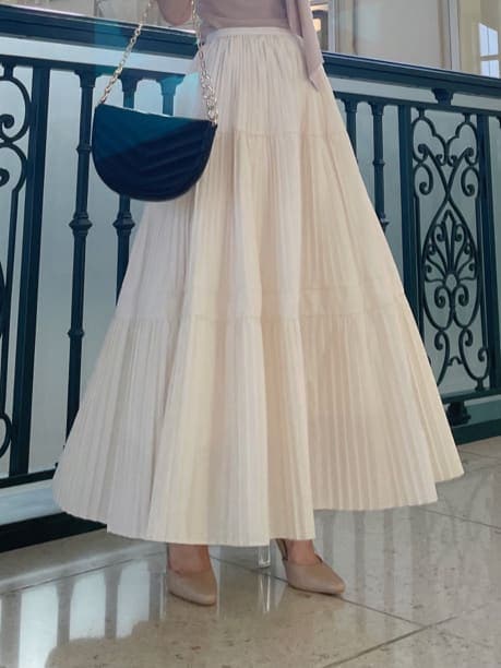 ホワイト系のスカート、ベージュ系のパンプス、ピンク系のニット/セーターを着用したレディースの秋コーディネートの4枚目の写真