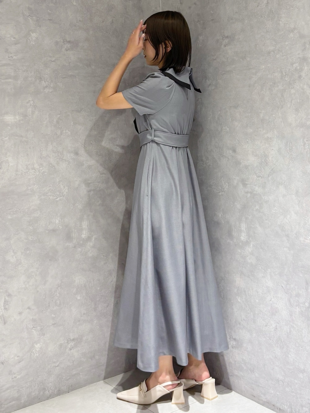 グレー系のワンピース、ホワイト系のパンプスを着用したレディースの春コーディネートの3枚目の写真
