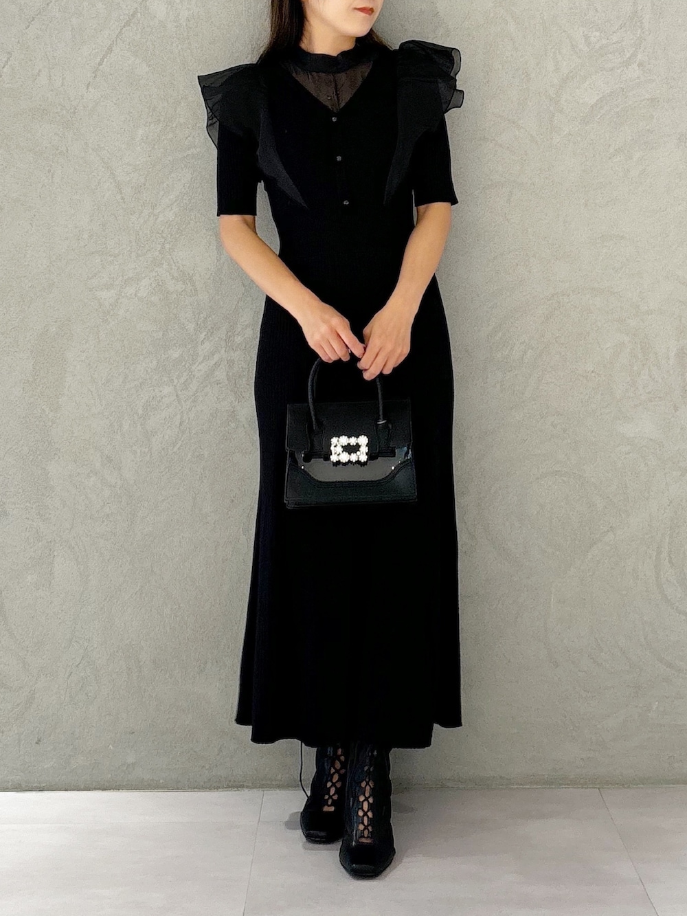 ブラック系のワンピース、ブラック系のショルダーバッグ、ブラック系のブーツを着用したレディースの夏コーディネートの3枚目の写真