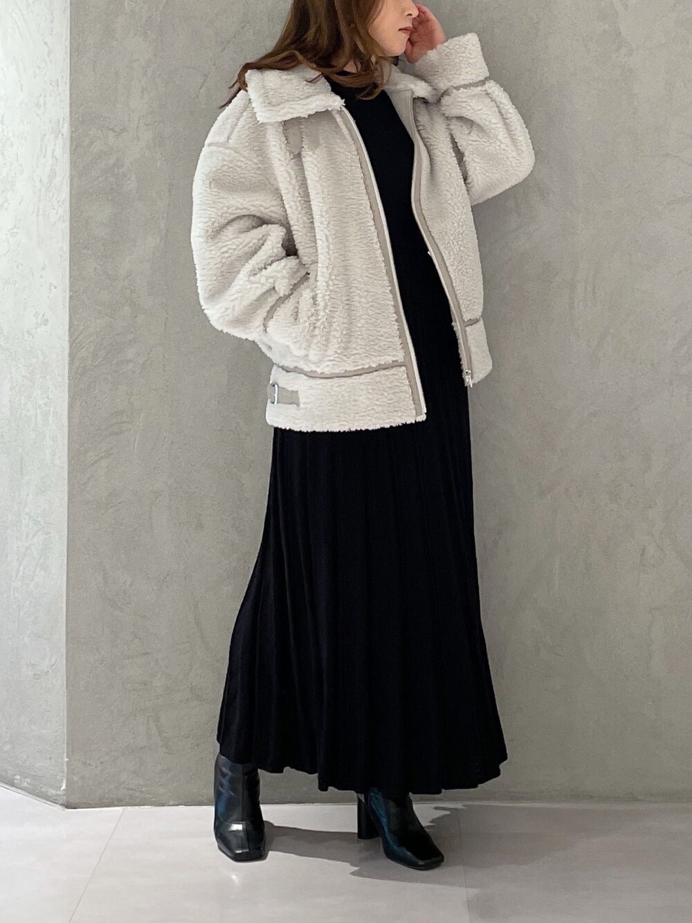 ブラック系のワンピース、ブラック系のブーツ、グレー系のその他アウターを着用したレディースの冬コーディネートの2枚目の写真