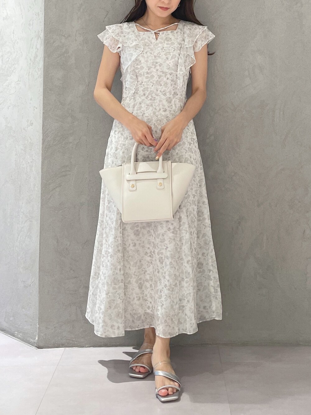 ホワイト系のワンピース、シルバー系のサンダル、ホワイト系のトートバッグを着用したレディースの夏コーディネートの5枚目の写真