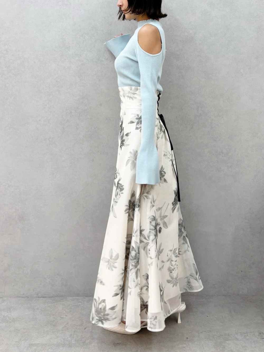 ホワイト系のスカート、グリーン系のニット/セーター、ホワイト系のパンプスを着用したレディースの春コーディネートの7枚目の写真